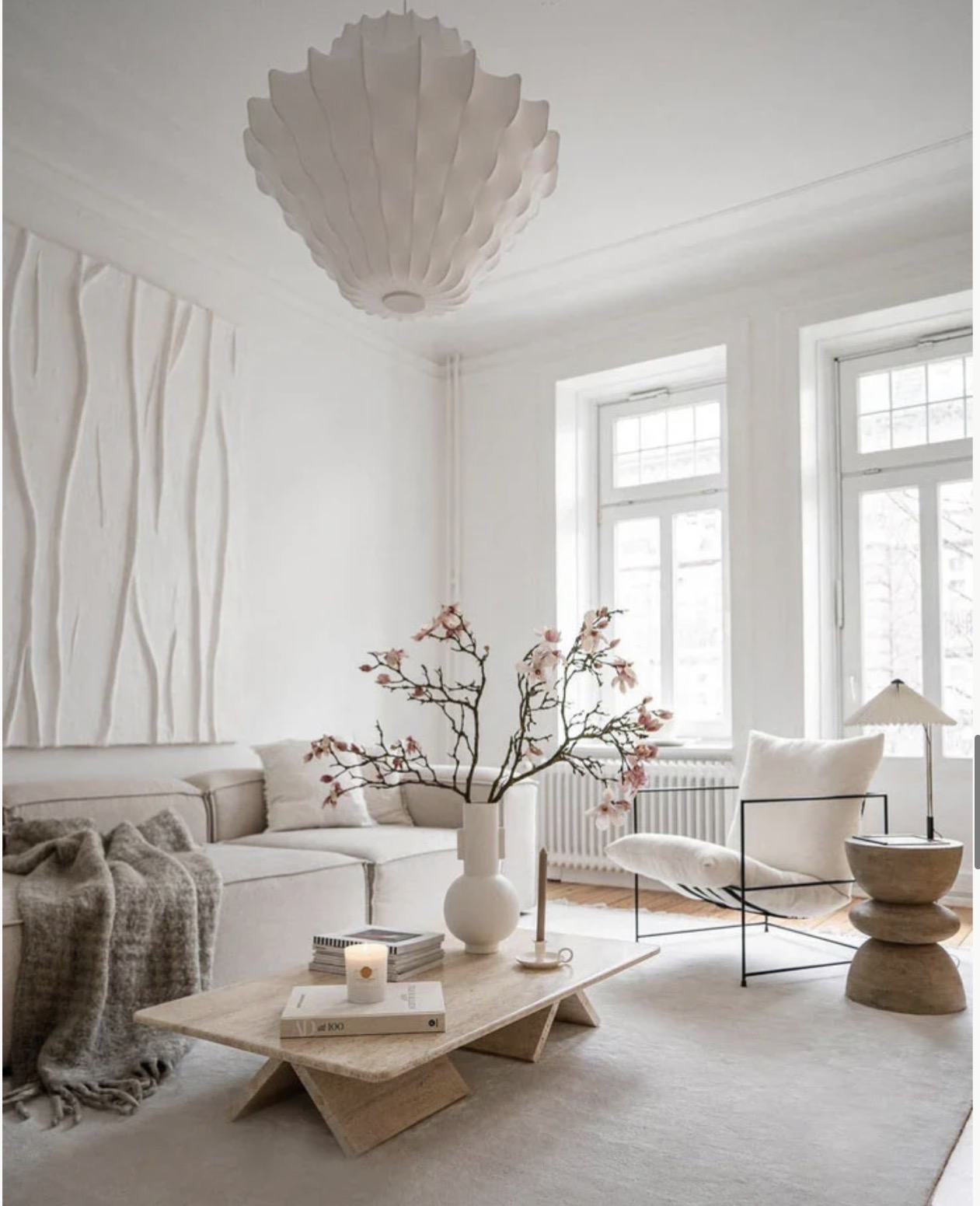 White living room with windows and blossom branches